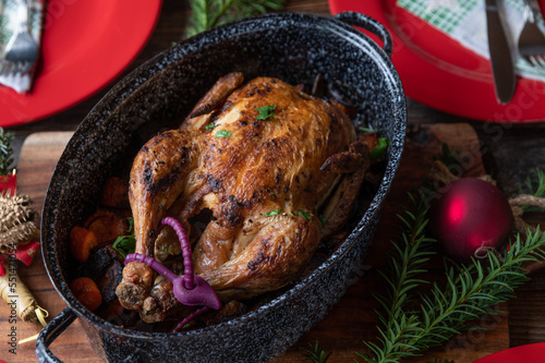 Quadro em tela Christmas roast chicken with vegetables and sauce in a old fashioned roaster on