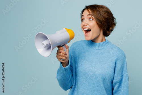 Cuadro en lienzo Young surprised shocked excited fun woman wears knitted sweater hold in hand megaphone scream announces discounts sale Hurry up look aside isolated on plain pastel light blue cyan background studio