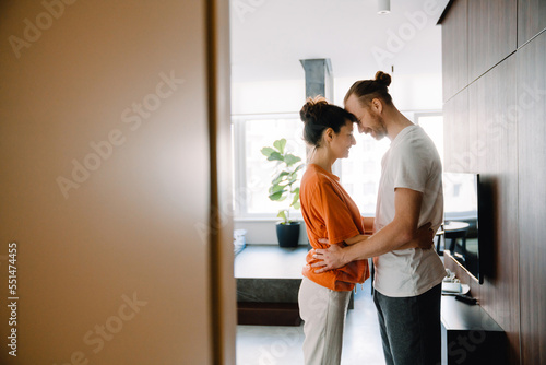 Young white couple smiling and hugging together in bedroom at home