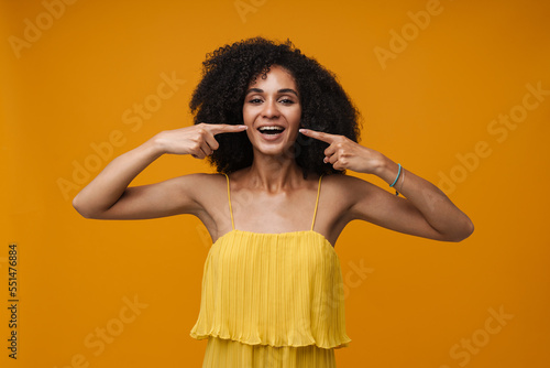 Portrait of young beautiful happy curly woman poiting with fingers