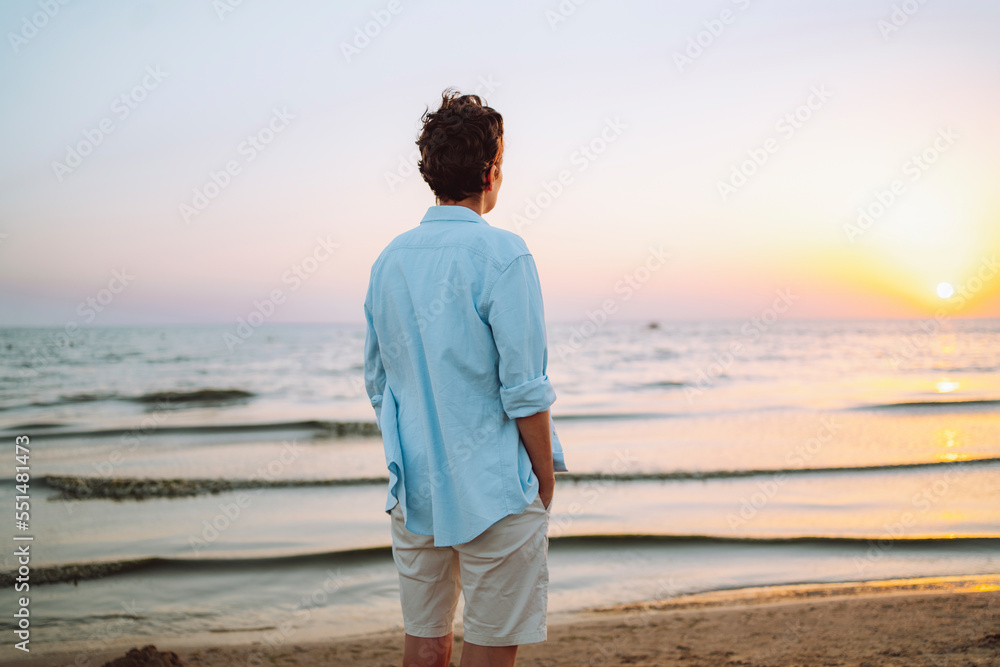 Androgynous woman looking at sea on sunset Androgynous woman looking at sea on sunset