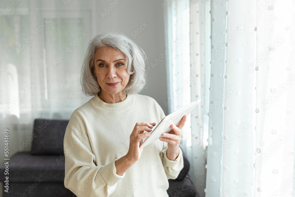 Senior woman holding digital tablet at home Senior woman holding digital tablet at home