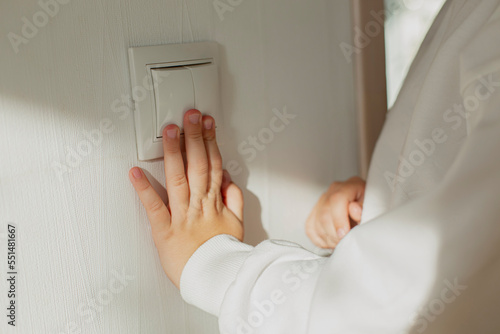 Hand pressing light switch on the wall