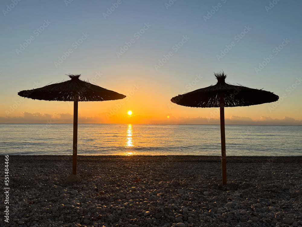 Parasol with sunrise on the beach