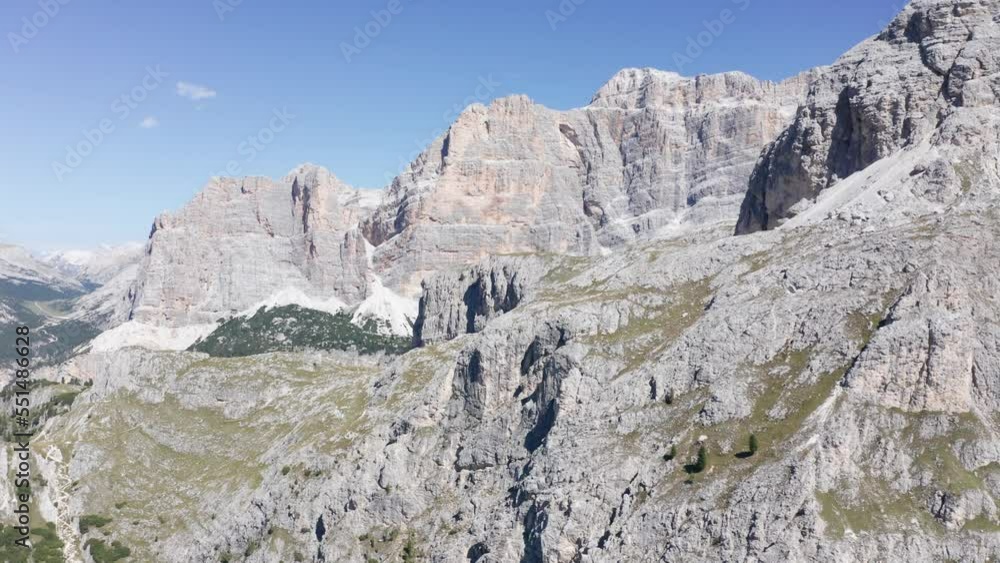 Aerial drone flight showing Fanes Nature Park with gigantic mountains in sunlight with blue sky - Val Badia in the valley Aerial drone flight showing Fanes Nature Park with gigantic mountains in sunlight with blue sky - Val Badia in the valley