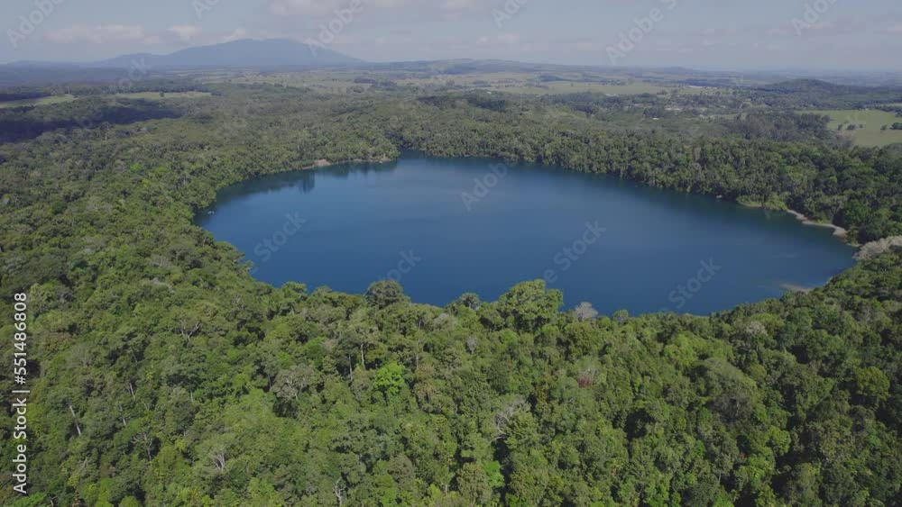 Lake Eacham Surrounded With Lush Vegetation In Atherton Tableland, Queensland, Australia - aerial drone shot Lake Eacham Surrounded With Lush Vegetation In Atherton Tableland, Queensland, Australia - aerial drone shot