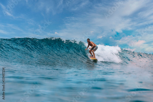 Shirtless male surfer on a wave at sunny day