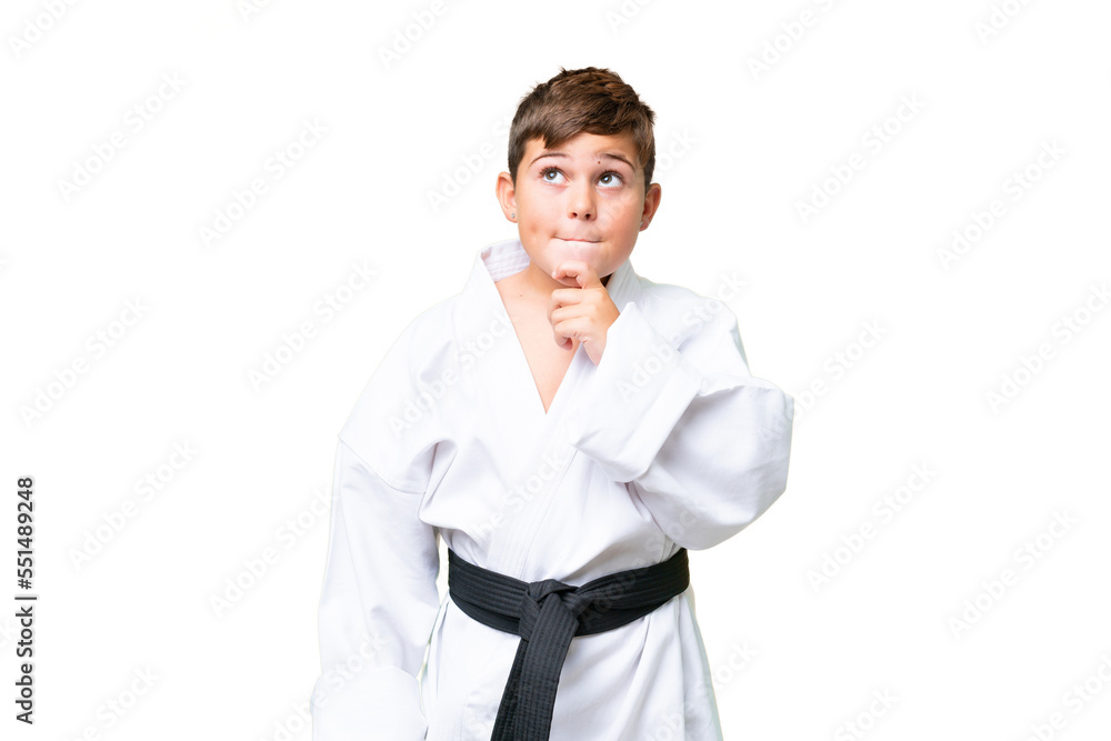 Little caucasian kid doing karate over isolated chroma key background having doubts and thinking Little caucasian kid doing karate over isolated chroma key background having doubts and thinking