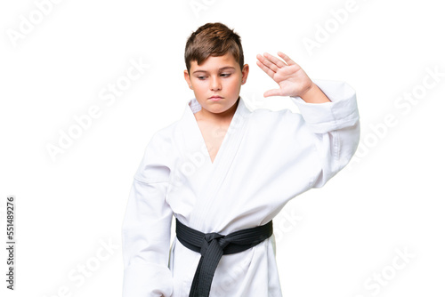 Little caucasian kid doing karate over isolated chroma key background making stop gesture and disappointed