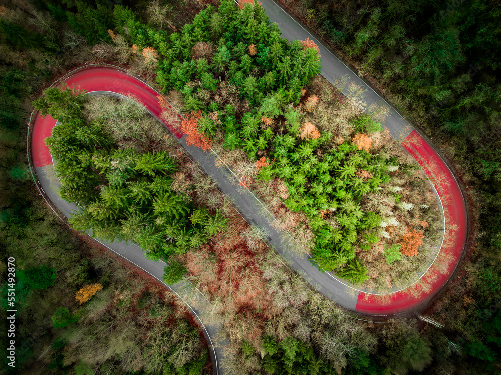 Aerial view of winding road on mountain in Autumn twisty road autumn forest colorful path