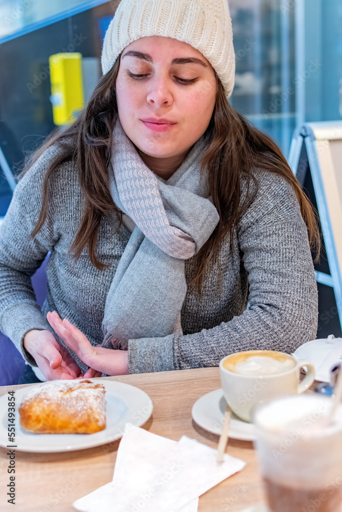 Young woman having breakfast with croissant and coffee at the cafe bar. Young woman having breakfast with croissant and coffee at the cafe bar.