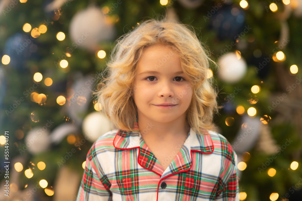 Happy funny child in winter pajama near Christmas tree at morning. Christmas and New Year concept. Happy funny child in winter pajama near Christmas tree at morning. Christmas and New Year concept.