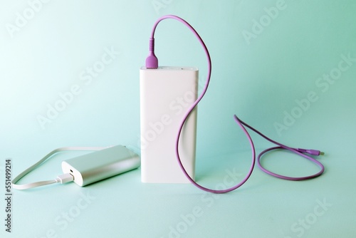 Power bank, external battery and usb wire on the table, universal mobile battery for charging gadgets, for recharging a smartphone