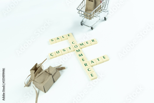 E-commerce concept text isolated on white, sale customer e-commerce and rate text, online shopping banner idea, trolley and cardboard boxes