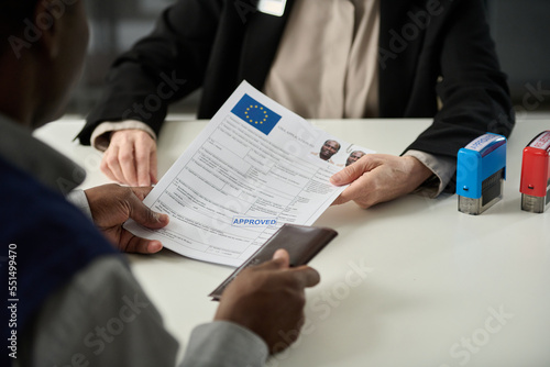 Tableau sur toile Close up of unrecognizable consulate worker handing approved visa application fo