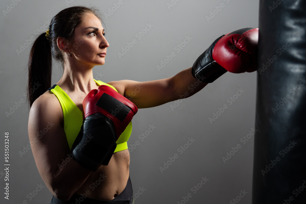 A young woman trains on a punching bag