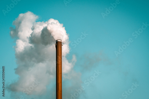 Billede på lærred Factory chimney blowing white smoke from pipe in blue sky