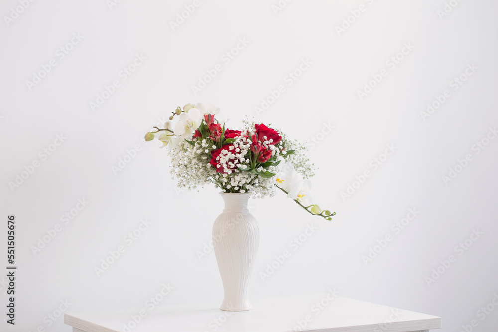 red and white bouquet in vase on white background