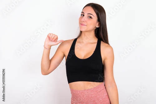 Closeup of cheerful MODEL looks joyful  satisfied and confident  points at himself with thumb.