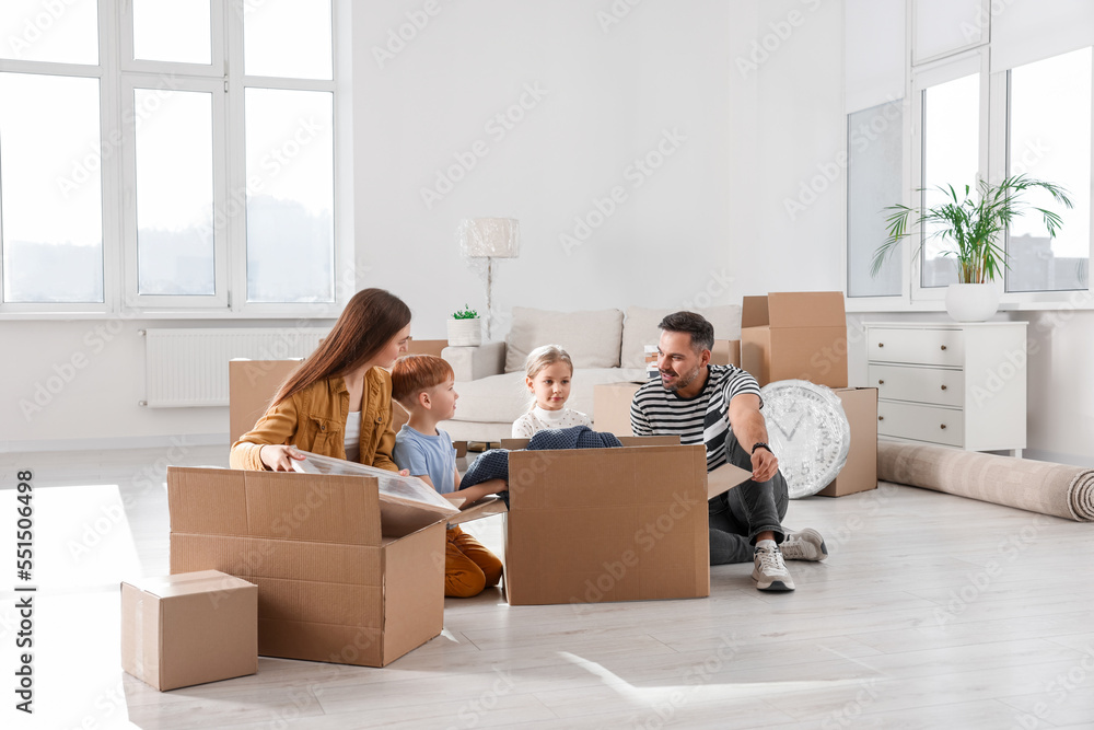 Family unpacking boxes in new apartment. Moving day Family unpacking boxes in new apartment. Moving day