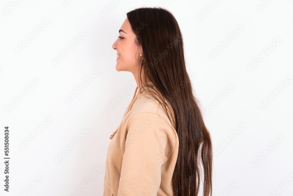 Profile portrait of nice Young caucasian woman wearing sweatshirt over white background look empty space toothy smile Profile portrait of nice Young caucasian woman wearing sweatshirt over white background look empty space toothy smile