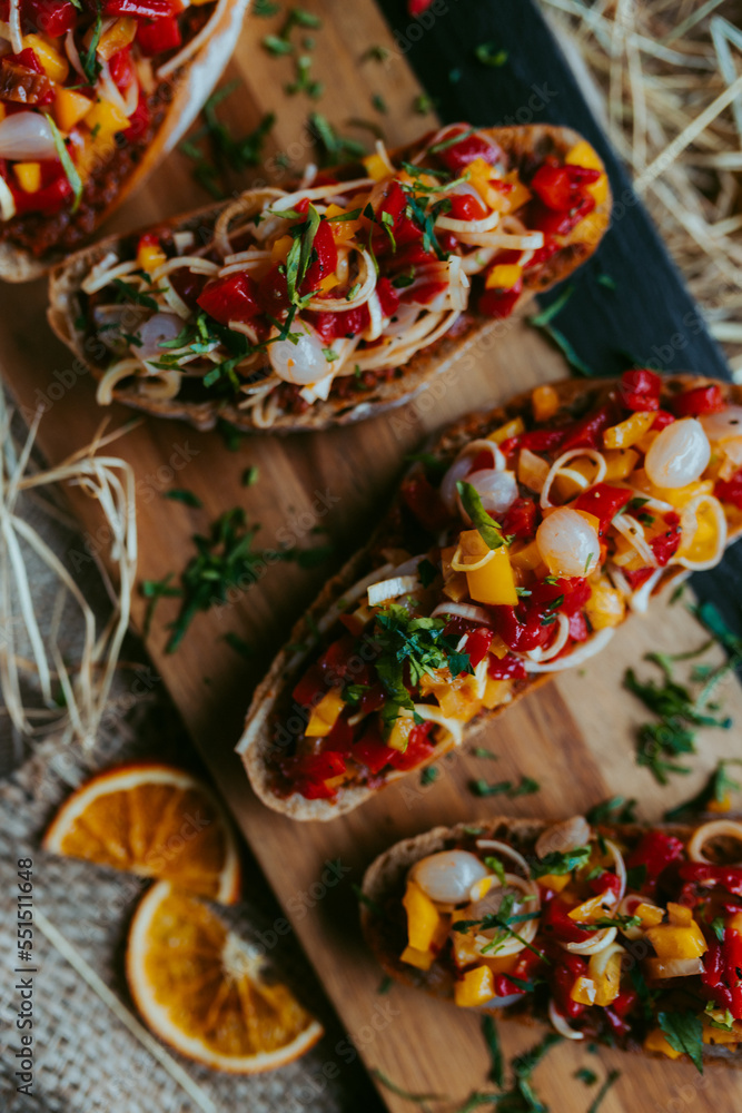 Brushetta set for party, Variety of small sandwiches with ,mushrooms, tomatoes, parmesan cheese, fresh basil and balsamic  on rustic wooden board over dark background