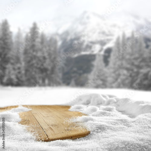 Wooden desk cover of snow flakes and winter landscape of free space.  © magdal3na