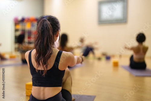 young asian girl doing yoga together with other people