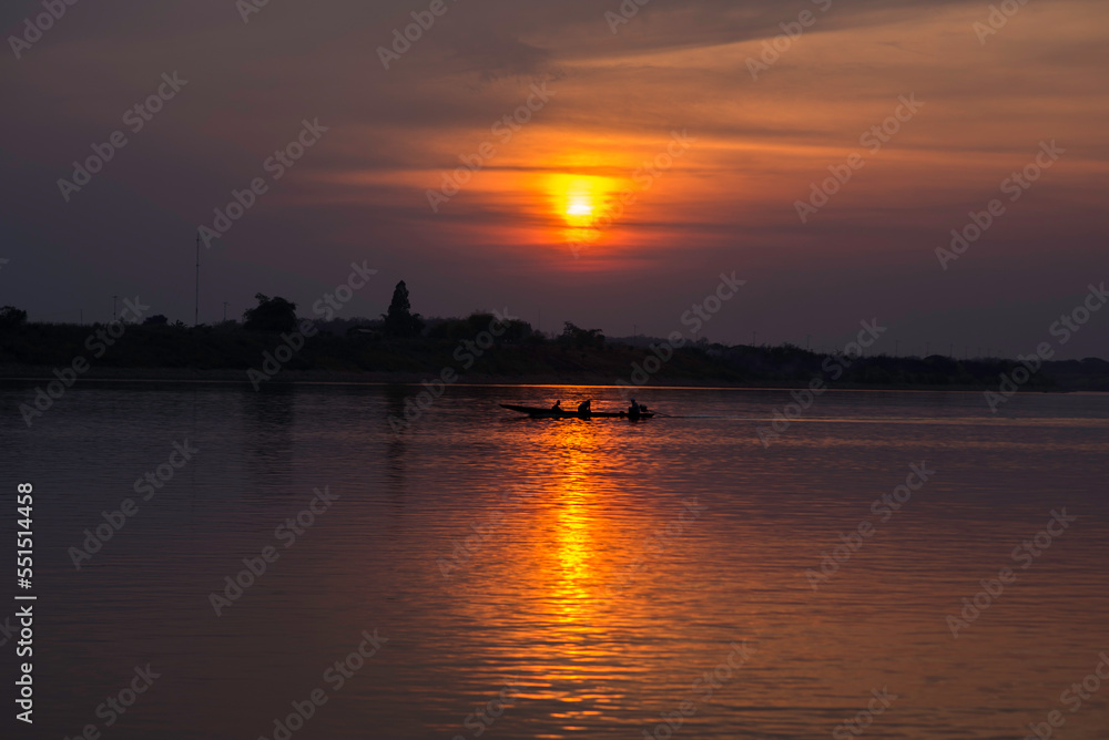 Naklejka premium the boat runs through th sunset in mekhong river sunset over the river