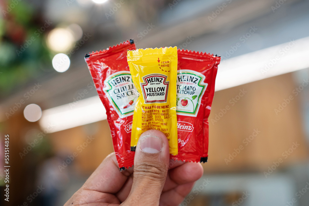 SINGAPORE APR 20, 2022 Hand holding sachets of Heinz chilli sauce