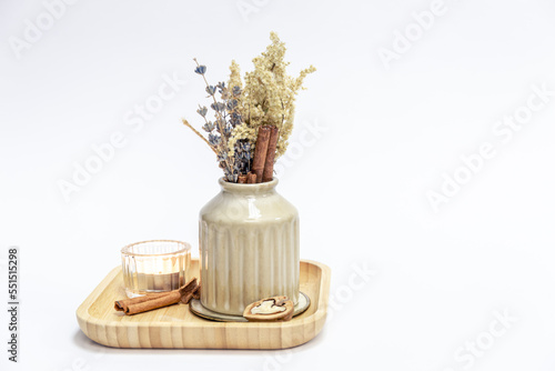 Vase with dried flowers and a candle on a white background isolated. photo