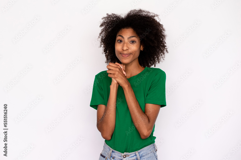 Portrait of funny young woman expressing love and admiration over white background. African American lady wearing green T-shirt and jeans looking at camera and clasping hands. Admiration concept Portrait of funny young woman expressing love and admiration over white background. African American lady wearing green T-shirt and jeans looking at camera and clasping hands. Admiration concept
