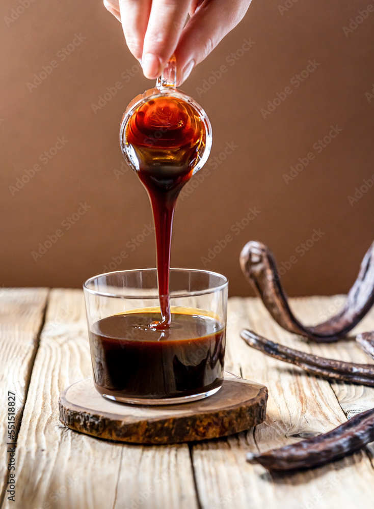 Ταπετσαρία Healthy carob molasses and woman hand pouring liquid to the cup from glass jar,