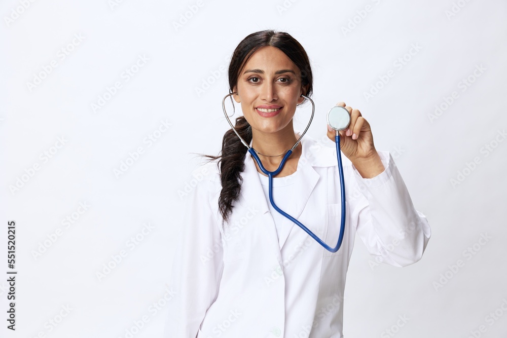 Woman doctor with stethoscope in hand in medical gown on white nurse background, consequences of covid-19, noise in lungs, concept of health and science Woman doctor with stethoscope in hand in medical gown on white nurse background, consequences of covid-19, noise in lungs, concept of health and science