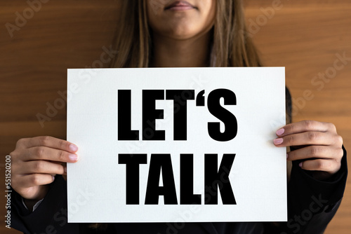 Let's talk. Woman holds a white page with orange text. communication, business, discussion, talking, ideas and inspiration photo