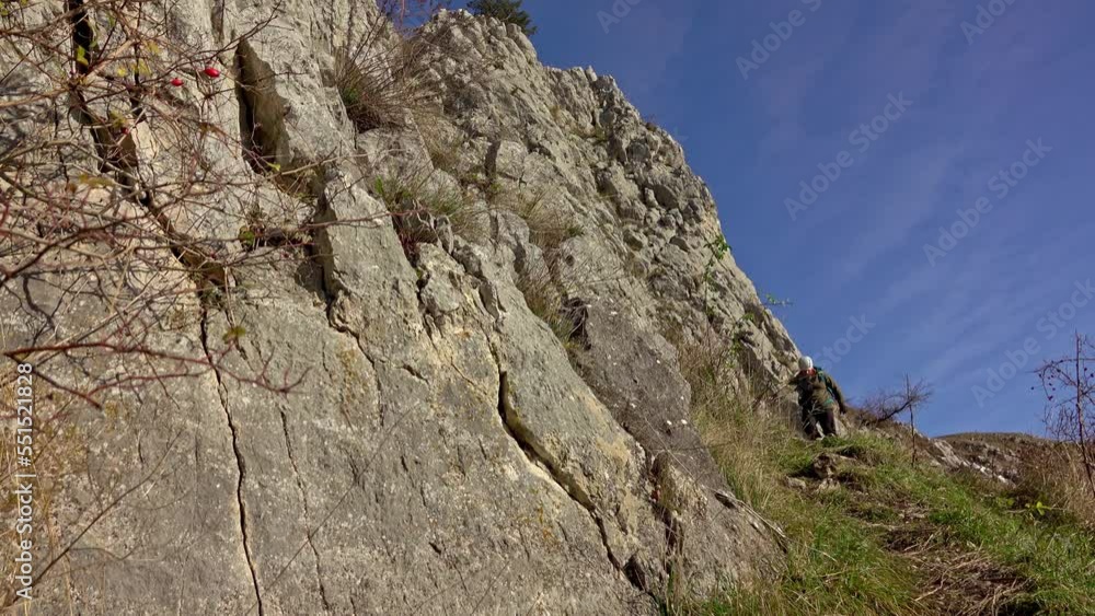 Hiking the steep scree terrain to the summit of the mountain in an autumn sunny day with blue sky Hiking the steep scree terrain to the summit of the mountain in an autumn sunny day with blue sky