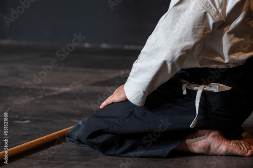 Black belt aikido master in seiza traditional sitting. Copy space. photo