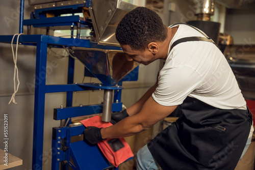 Worker sealing the coffee bag with a heat sealer