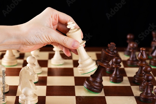 Hand with king chess piece plays chess. Leadership, fighter, competition, confrontation concept.