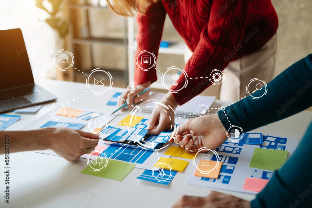 Obraz premium UI developer team brainstorming on their project with laptop, smartphone and digital tablet. Creative digital development agency...