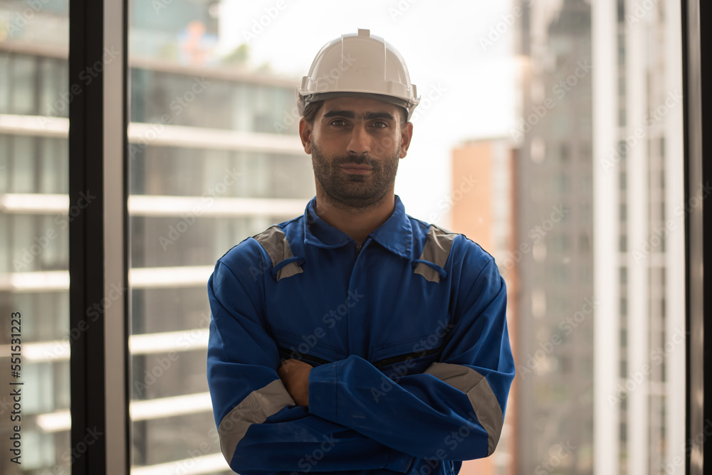 portrait of Handsome and Happy caucasian man worker have unkempt beard wearing safety uniform workwear standing and looking a camera in construction site. portrait of Handsome and Happy caucasian man worker have unkempt beard wearing safety uniform workwear standing and looking a camera in construction site.
