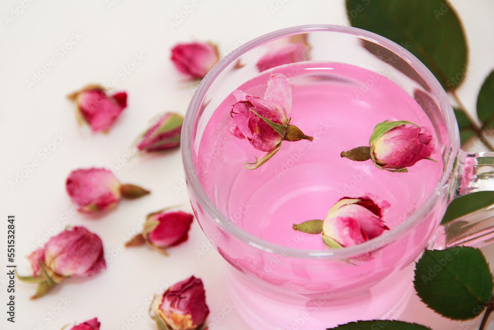 pink tea made from dried small rosebuds in a transparent mug on a white background pink tea made from dried small rosebuds in a transparent mug on a white background