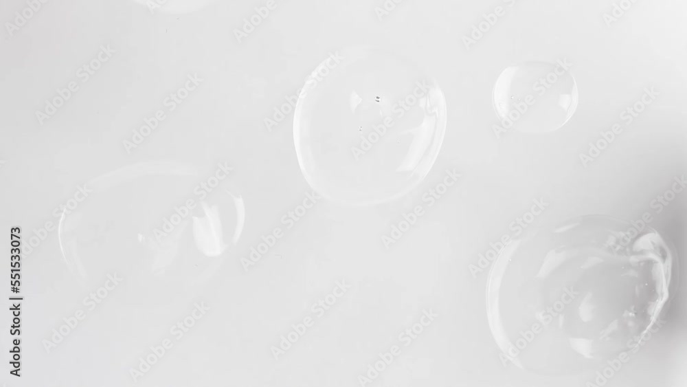 Transparent drops of hyaluronic acid with bubbles moving top view. Cosmetic product in liquid state. Transparent drops of hyaluronic acid with bubbles moving top view. Cosmetic product in liquid state.