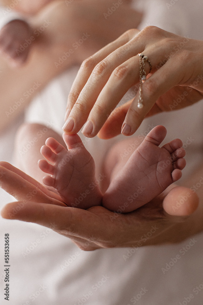 newborn baby feet on mom and dad hands. happy family concept newborn baby feet on mom and dad hands. happy family concept