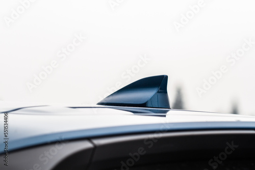 Modern car radio antenna. Shark fin antenna. Modern car roof.