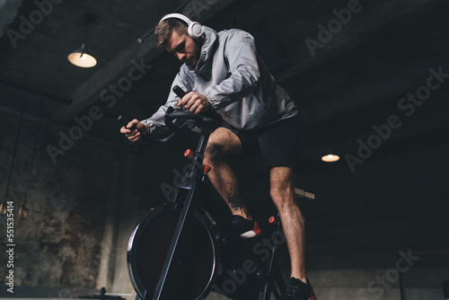 Panel kuchenny z motywem Man in headphones exercising on spinning cycle in gym