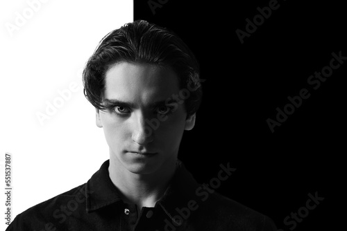 Black and white portrait of young man in classical shirt posing. Seriously looking at camera. Concept of men s fashion  business  emotions