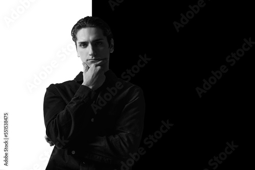 Black and white portrait of young man in classical shirt posing. Serious look. Concept of men's fashion, business, emotions
