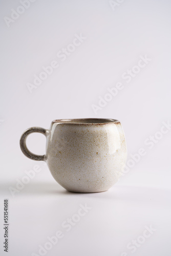Empty grey ceramic scandy coffee mug with brown rim and round handle on white seamless background, catalog photo