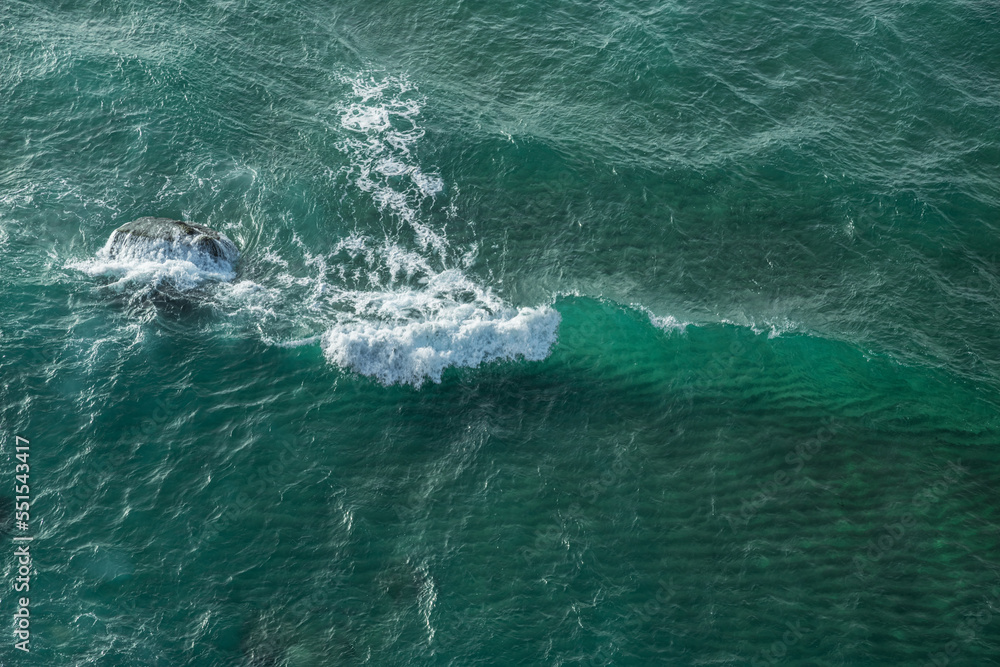 Ocean foamy waves approaching rocky shore. Top view. Ocean foamy waves approaching rocky shore. Top view.